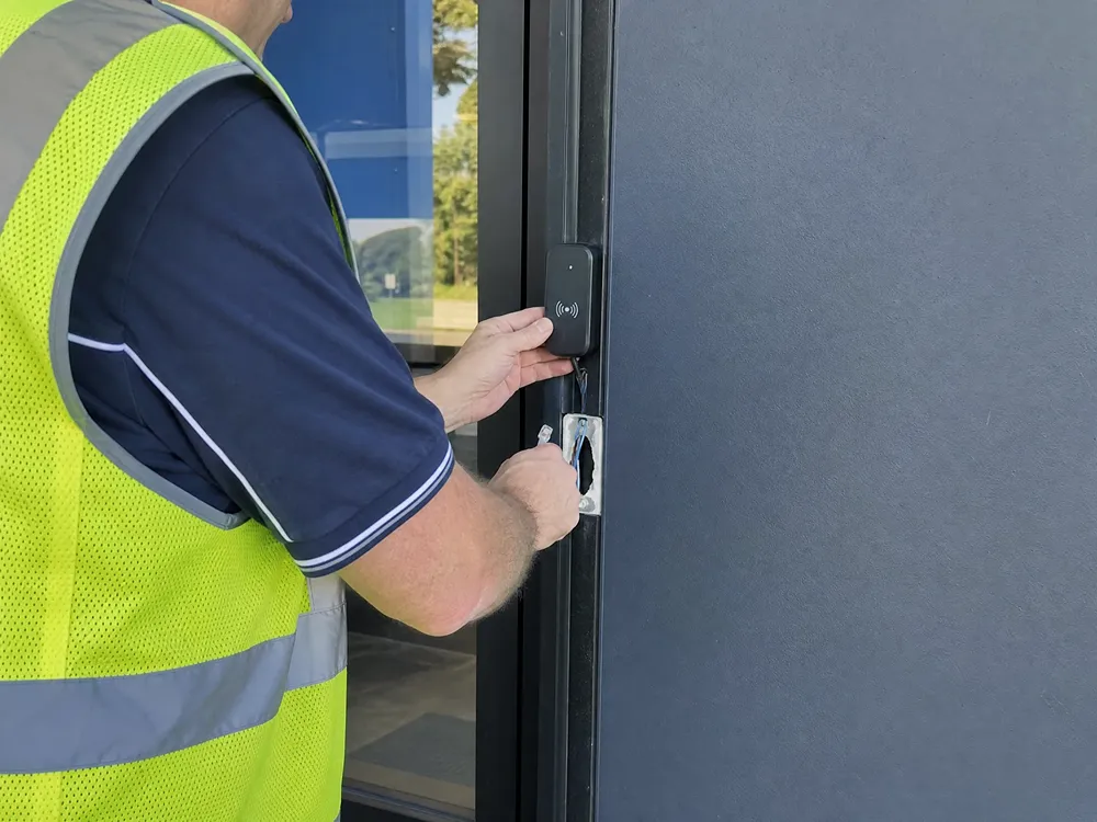 Technician installing an electronic access control reader in Brisbane, Queensland.